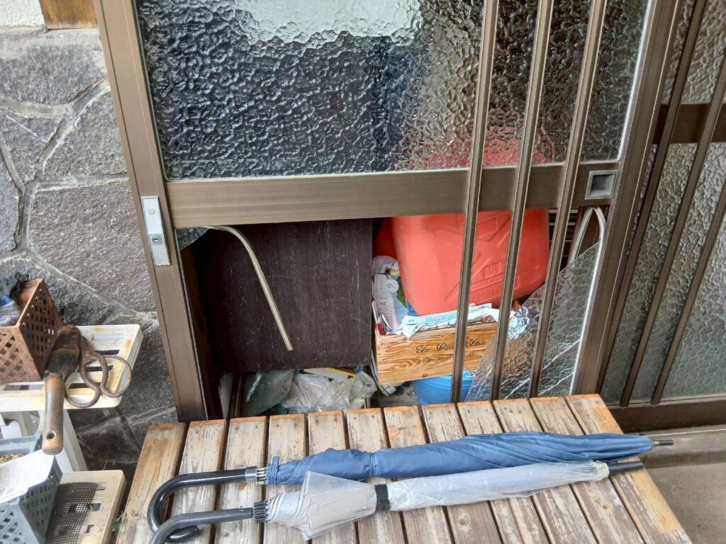 仙台市青葉区で撮影した玄関引き戸のガラス破損箇所。下部のガラスが大きく割れて欠損しており、屋外から室内が見えている状態。