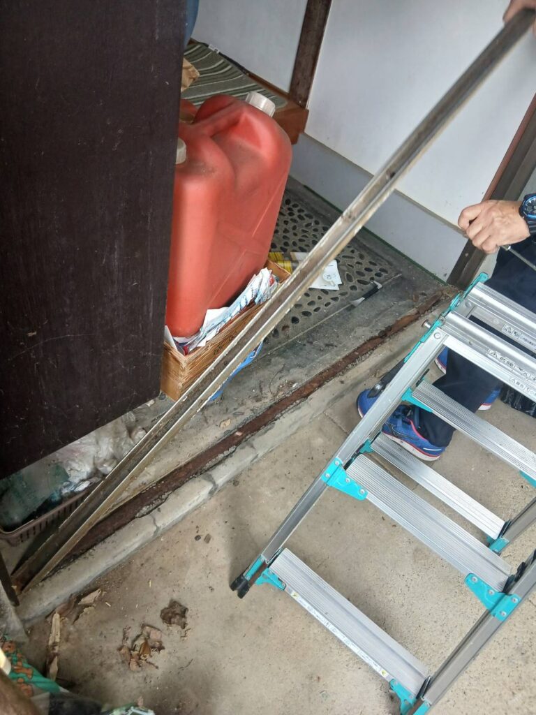 既存玄関ドアの取り外し作業風景(建具を外している様子)