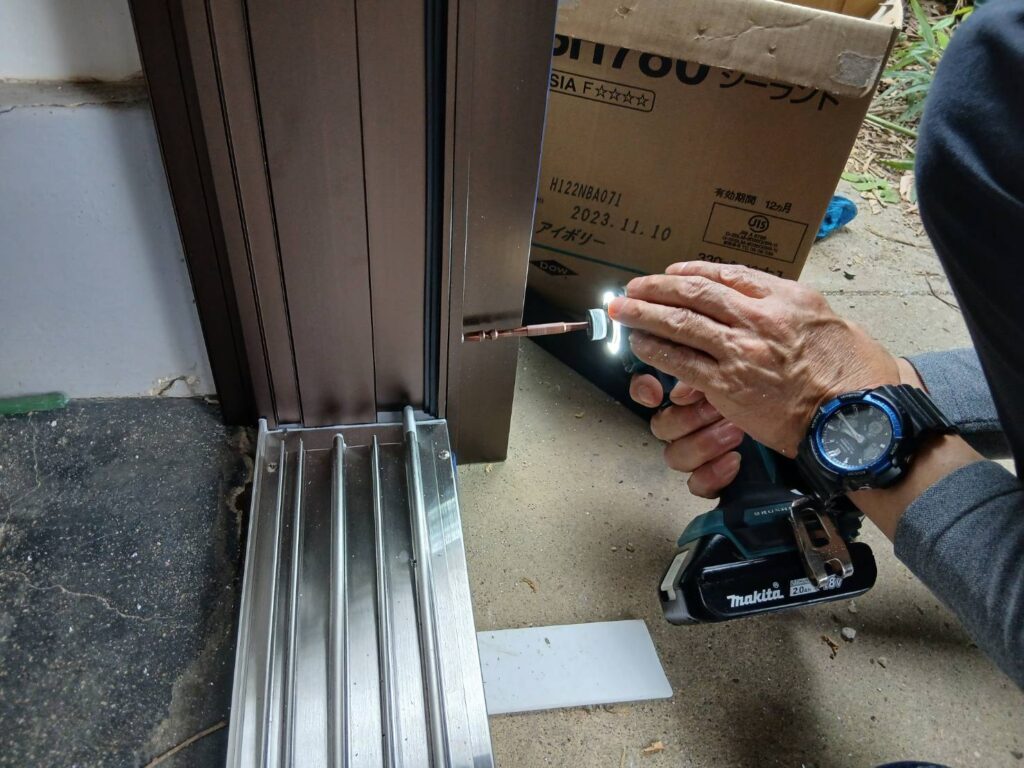 新しい玄関引き戸枠を調整している様子