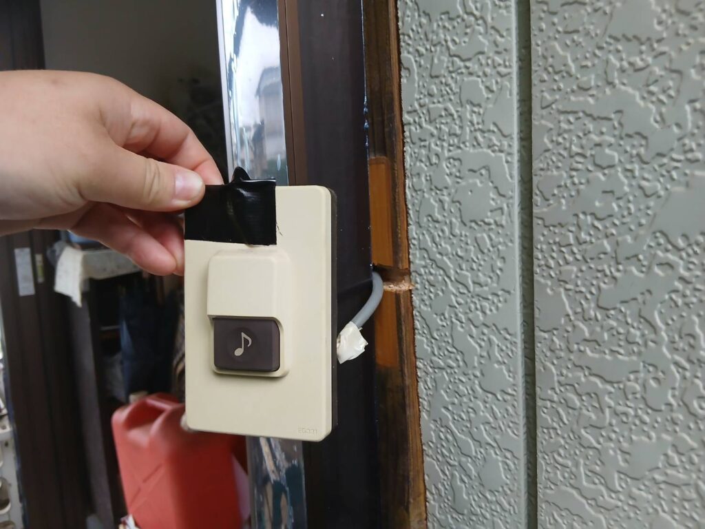 玄関横のチャイム子機を新しい位置に固定している様子