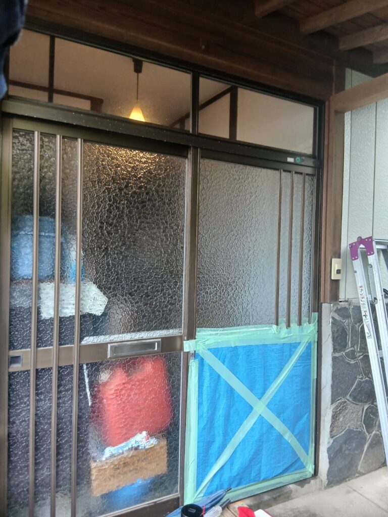 施工前の木製玄関引き戸(経年劣化で色あせ・開閉不良)