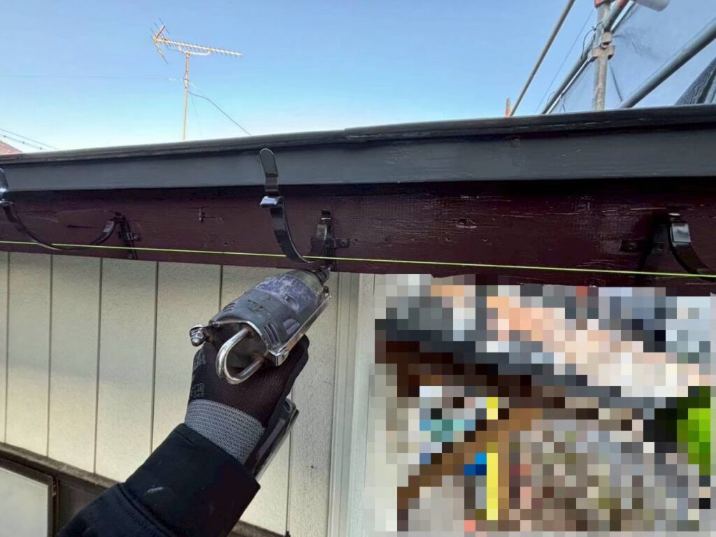 雨樋の金具を修理している作業