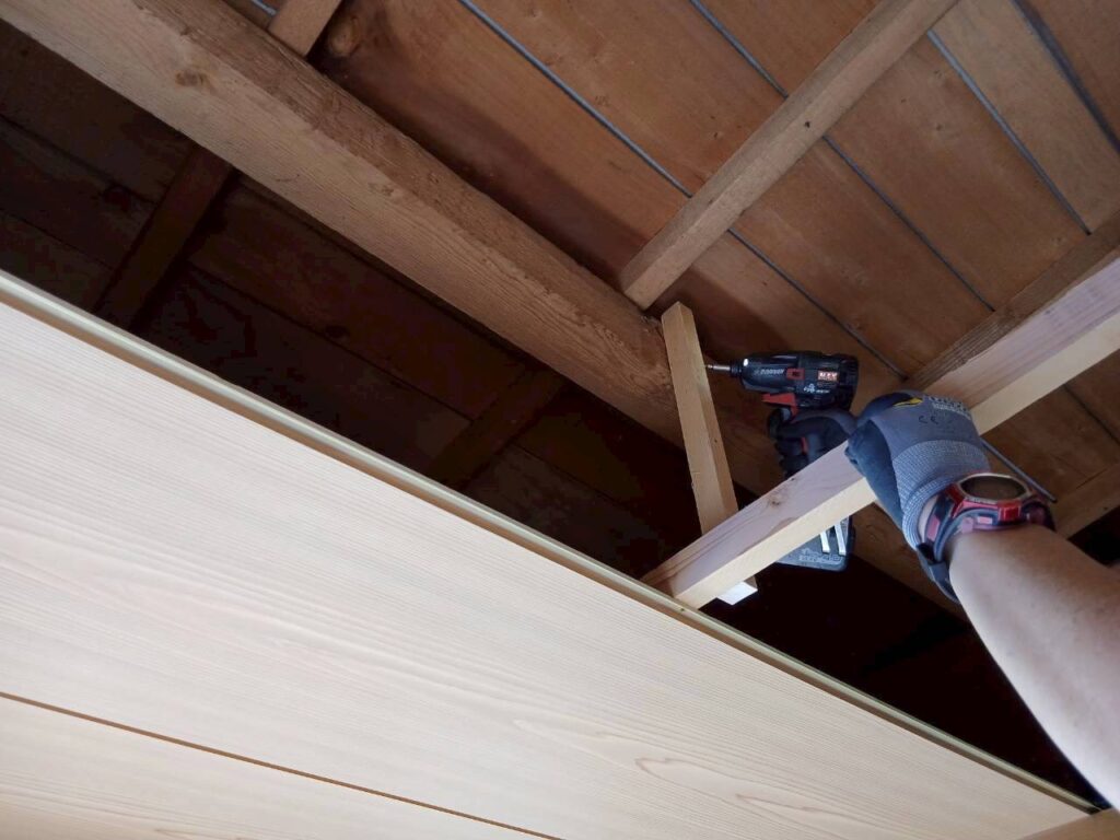 天井のたわみ防止のため吊り補強を入れながら目透かし天井を施工している様子