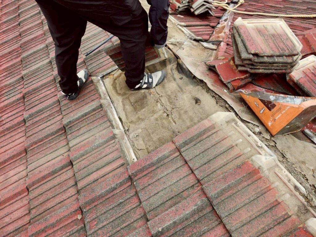 セメント瓦を一枚ずつ取り外している作業中の様子