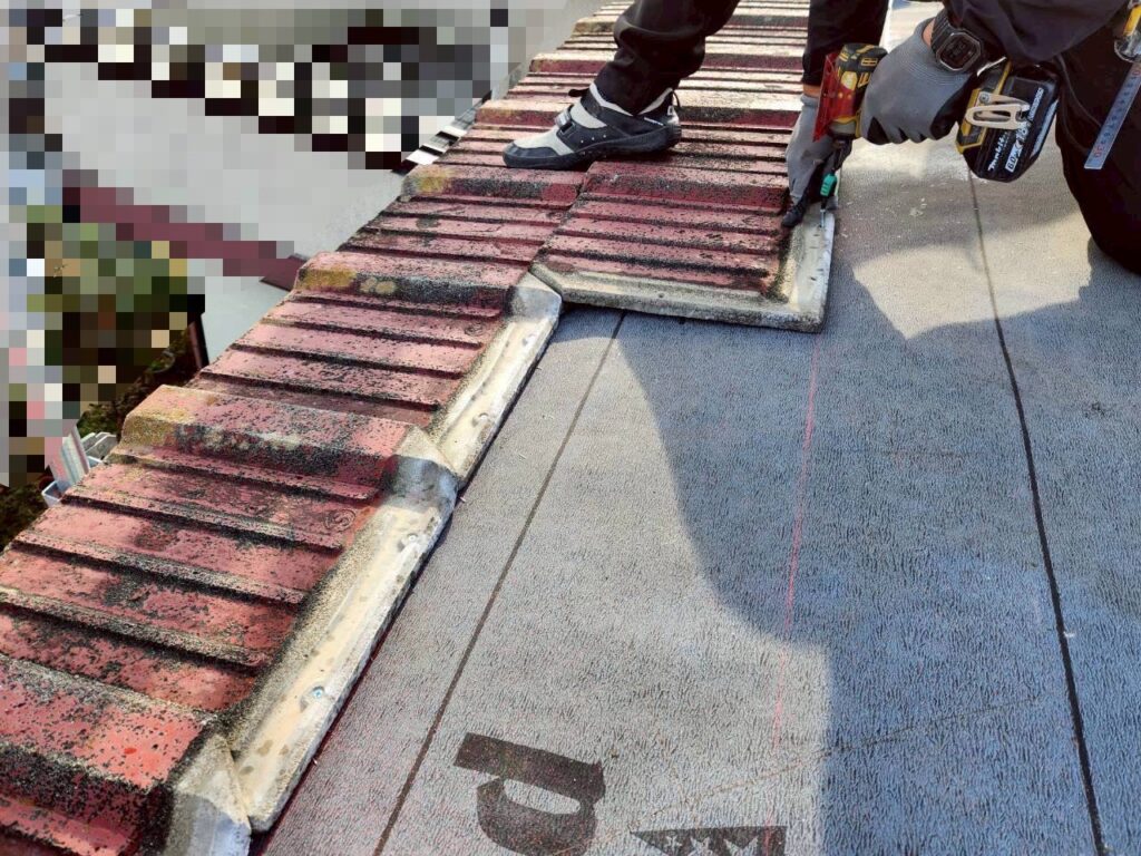 防水シートを下地にしっかり密着させている施工中の様子