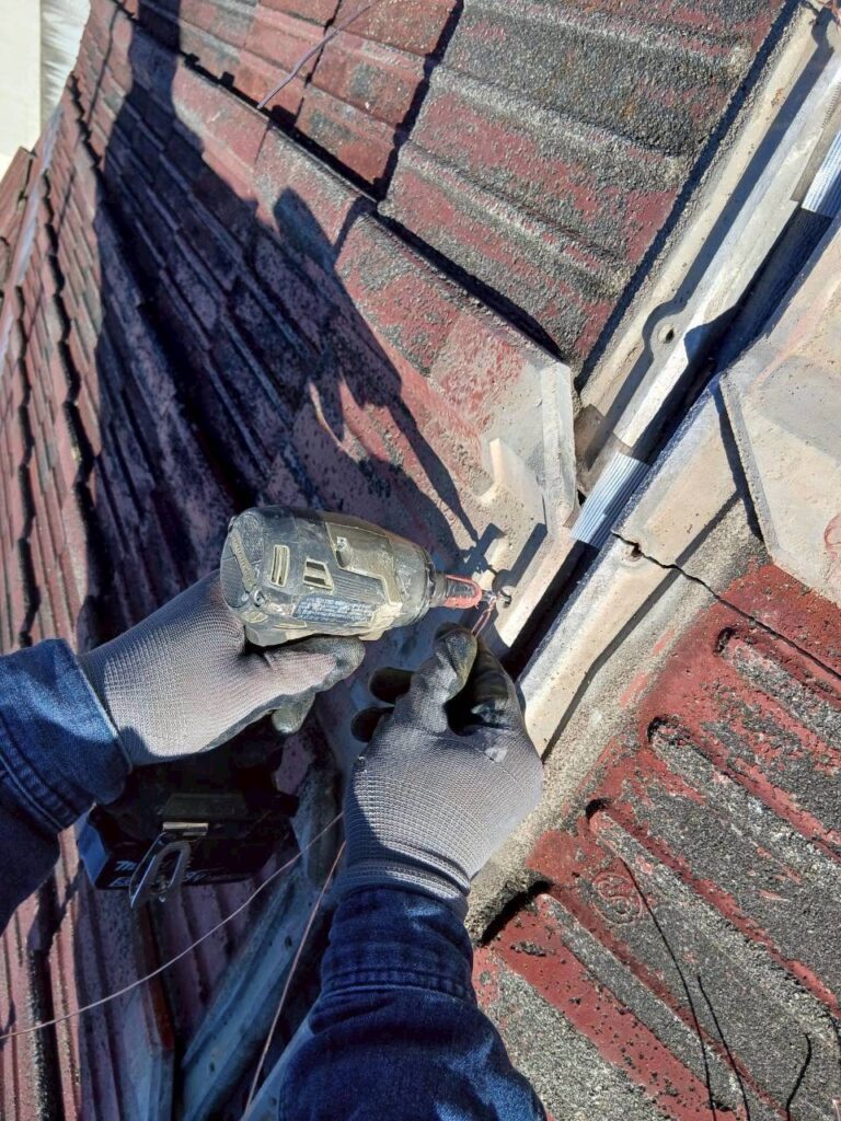 棟瓦を銅線で固定している作業中の様子