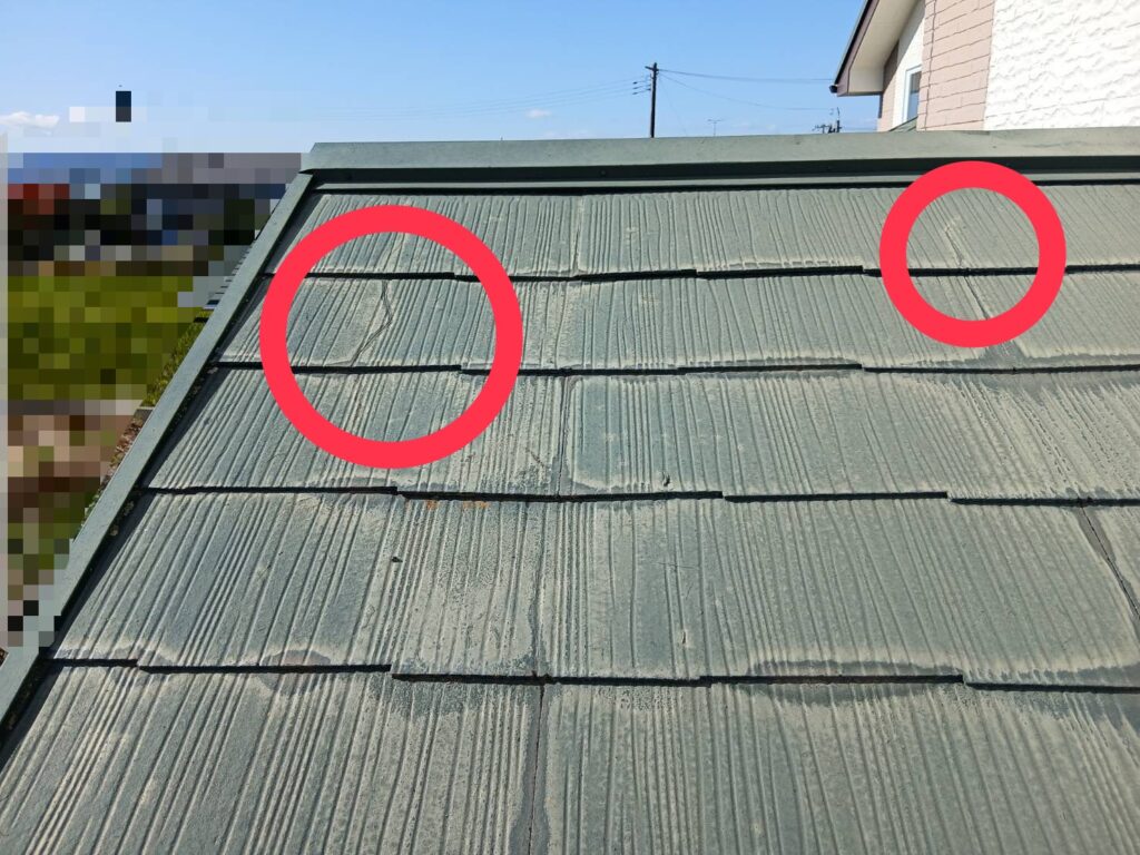 スレート屋根材に発生したヒビ割れの写真。屋根表面に複数の細い亀裂が確認できる状態。