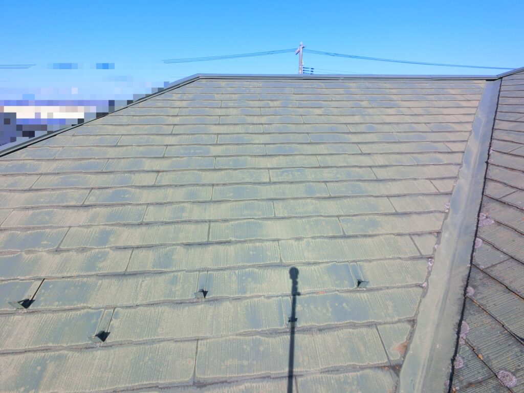 スレート屋根が全体的に色褪せ、表面の劣化が進んでチョーキングが発生している様子
