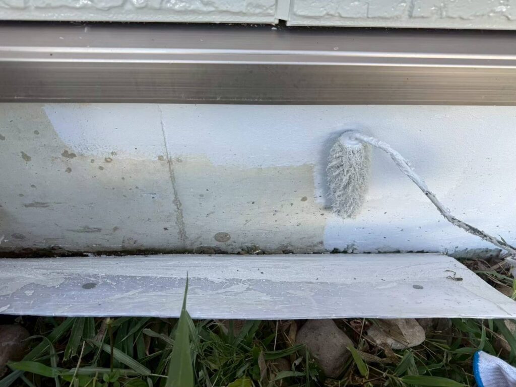 仙台市で基礎塗装の下塗りを行い、基礎コンクリート表面を整えている施工写真