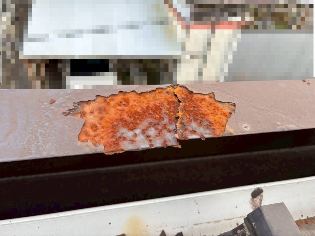 パラペット笠木の表面がサビで大きく腐食し、塗膜が剥がれて素地が露出している状態