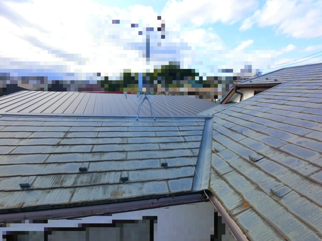 スレート屋根の谷板金まわりが劣化し始めている様子を撮影した写真(苔や汚れが目立ち雨漏りリスクが高い状態)