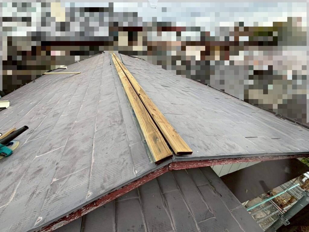 防腐処理された新しい木下地を棟部分に取り付けている様子