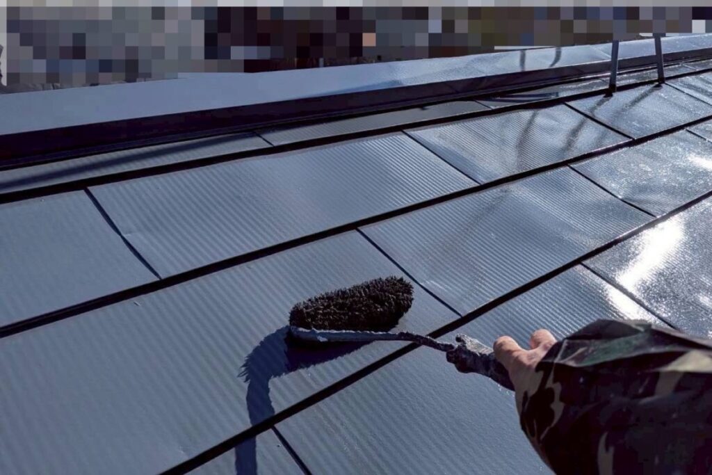 屋根塗装工事の仕上げとなる上塗り作業を行っている様子