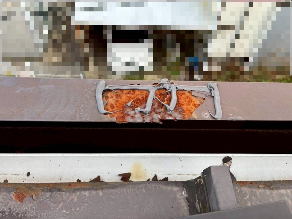 破風の穴あき部分にコーキング処理を行っている板金補修作業