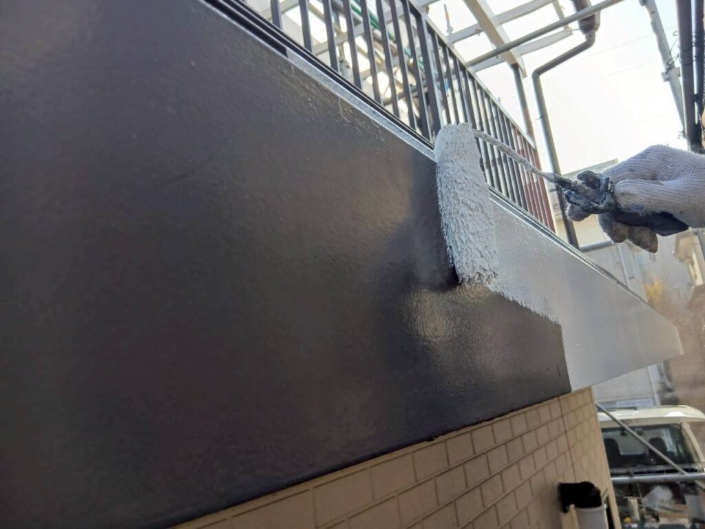 破風（パラペット）に塩ビゾルウレタンプライマーを塗布している様子