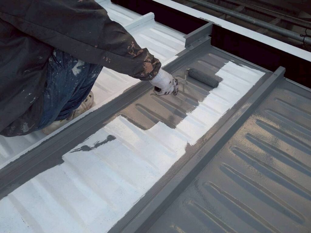 仙台市青葉区で金属屋根無機塗装の中塗りを大屋根に施工している様子