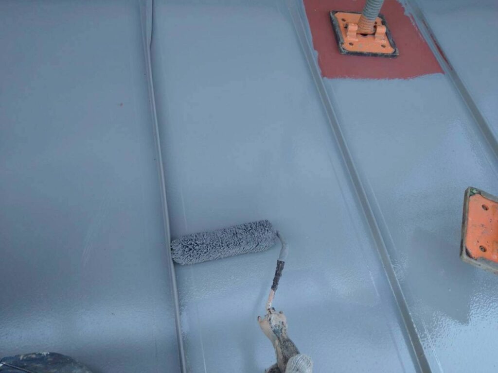 仙台市青葉区で玄関屋根に無機塗装の上塗りを行っている施工中写真