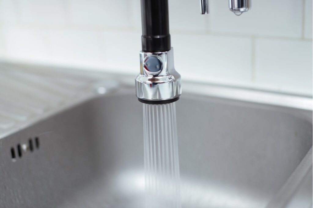 キッチンのシャワー付き水栓から水が出ている様子。ヘッドを引き出して使用できる水栓。