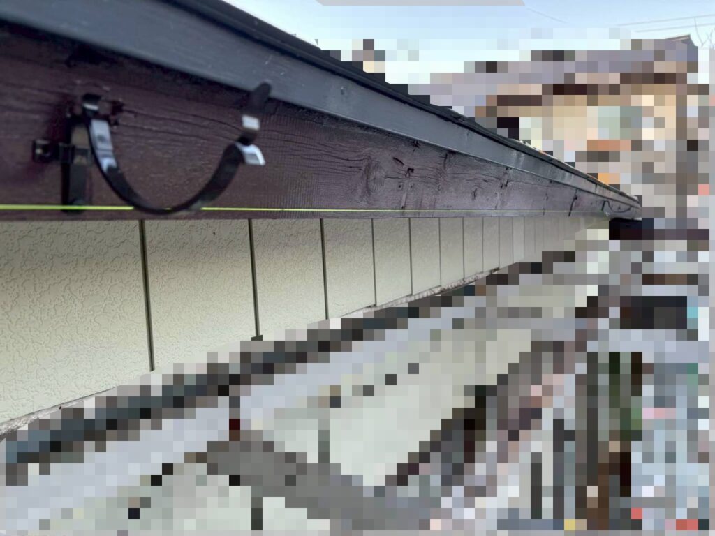 水糸を張って雨樋の勾配を調整している作業風景