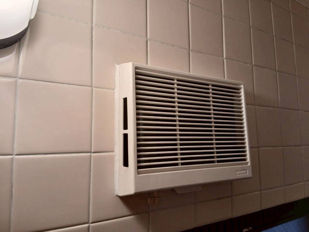 浴室に設置された壁付け換気扇の写真｜長年使用された換気扇を交換し正常に作動する状態