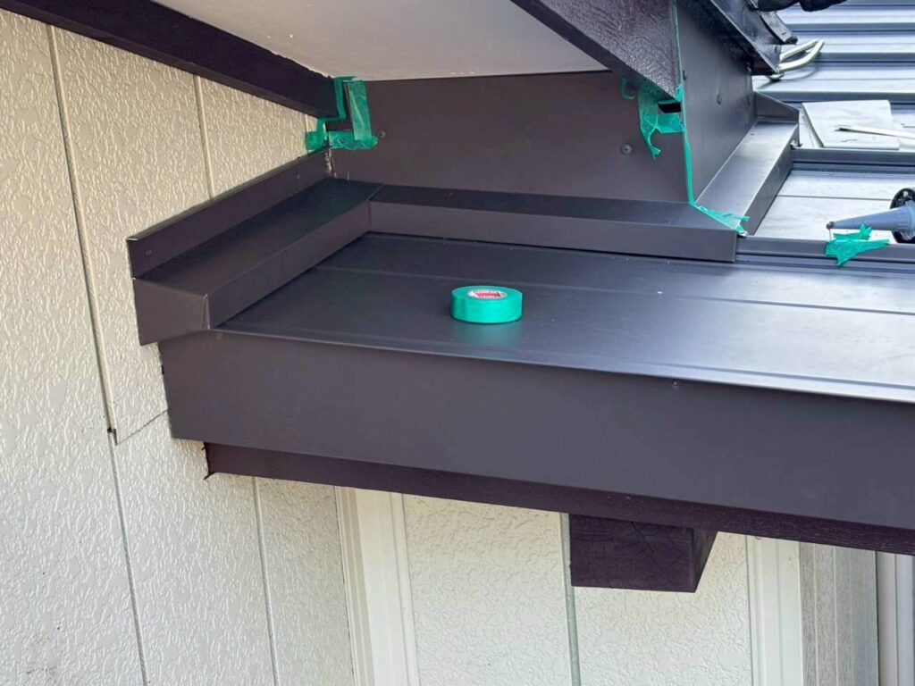 破風・壁まわり板金の継ぎ目にコーキングするためマスキング養生している様子