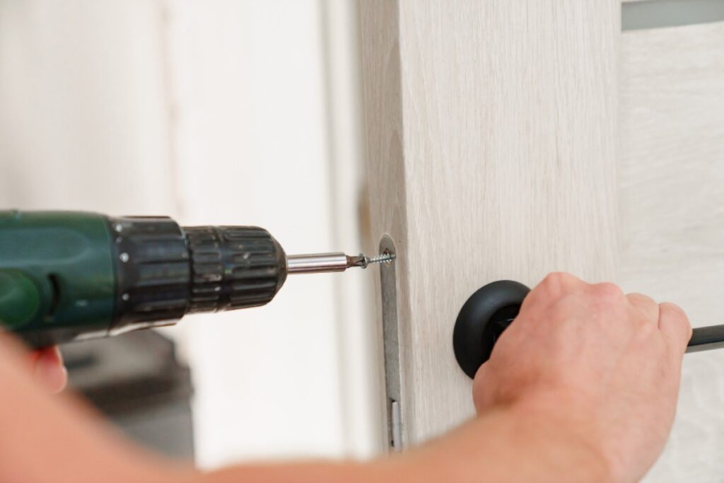 室内ドアの蝶番をドライバーで調整している様子｜開きにくいドアの原因確認
