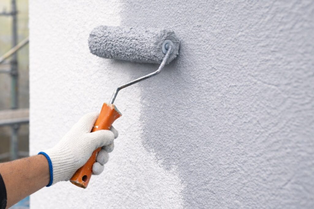 外壁塗装の施工中にローラーで塗料を均一に塗り広げている作業イメージ写真