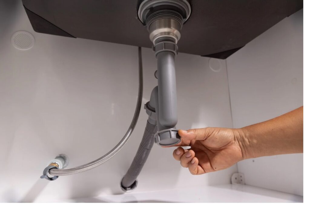 洗面台下の排水ホースとトラップ接続部を確認する様子｜臭い・水漏れチェック