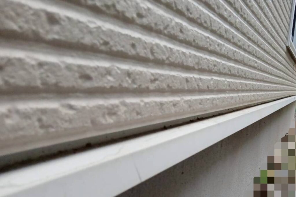 外壁下部と基礎の境目に設置された水切り板金の状態を撮影した現地写真