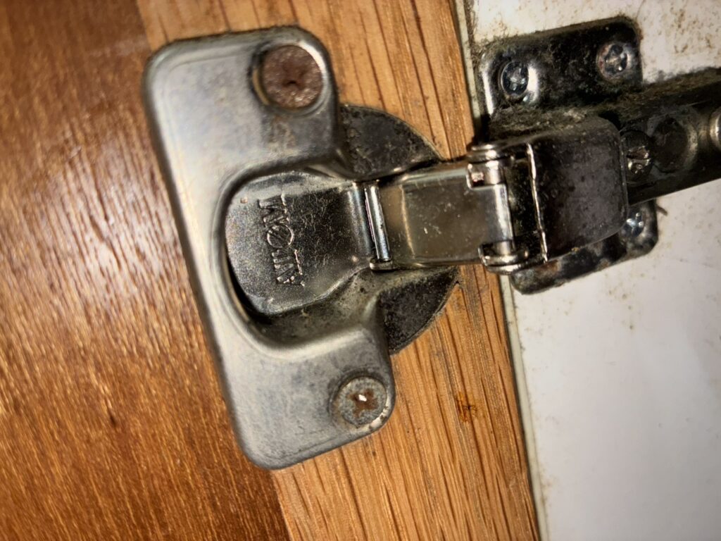 流し台扉の丁番不具合の実例｜ネジのサビ・ズレによる締まり不良の状態