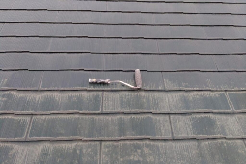 スレート屋根に下塗り塗料を施工している屋根塗装工事の様子
