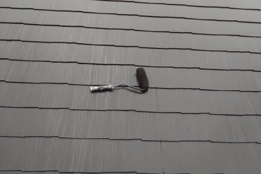 屋根塗装工事の上塗り作業中のスレート屋根の写真