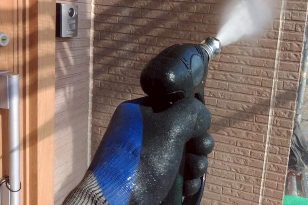 外壁の汚れや苔を落とす高圧洗浄作業の様子