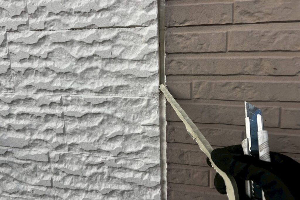 劣化した外壁コーキングを撤去している作業中の写真