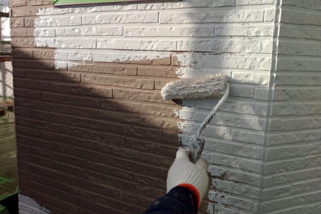 外壁塗装工事で下塗りを施工している作業写真