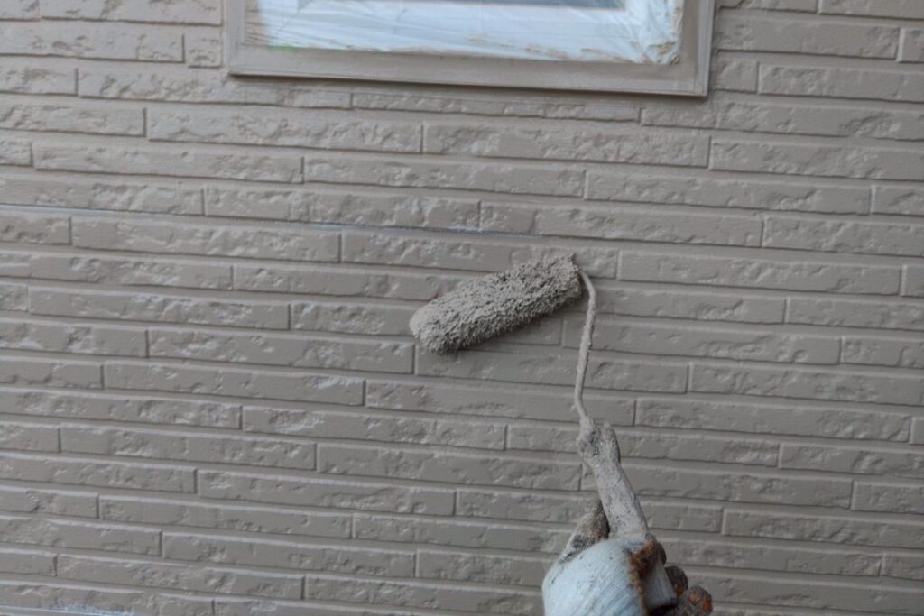 外壁塗装工事の上塗り作業で仕上げている様子