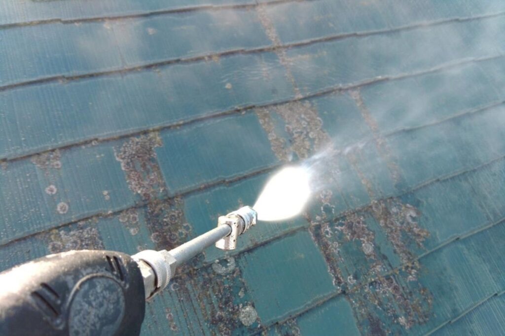 亘理郡で行った屋根塗装前の高圧洗浄作業の様子。屋根表面の苔や汚れを高圧水で丁寧に除去している