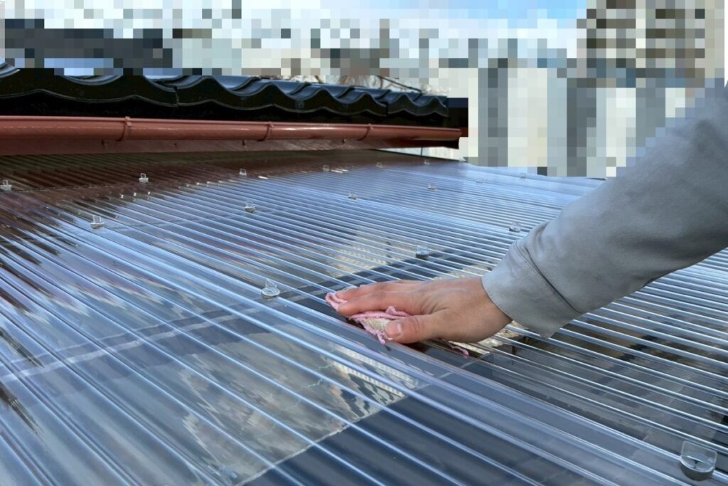 施工後に波板屋根を清掃している作業風景