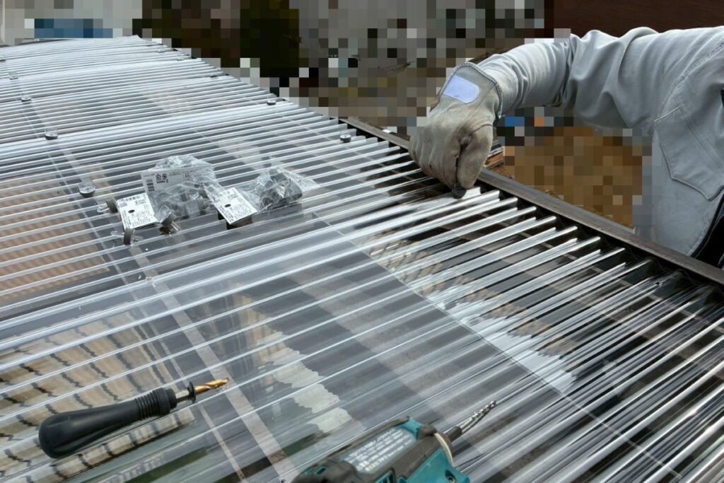 フック式留め具を使用して波板を固定している作業写真