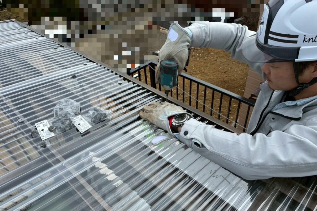 新しい波板に固定用の穴あけ加工を行っている作業写真