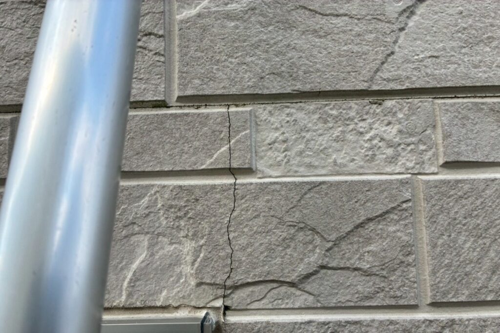 外壁サイディングに縦方向のヒビ割れ(クラック)が入っている施工前の状態