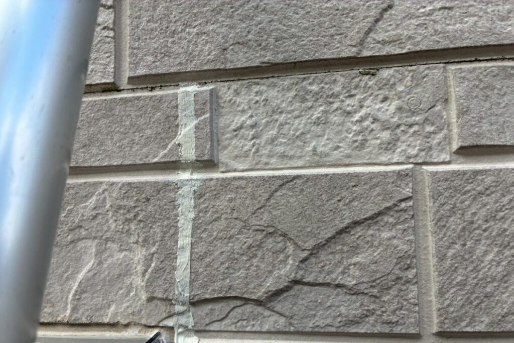 養生テープを剥がしてコーキング補修が完了した外壁の写真