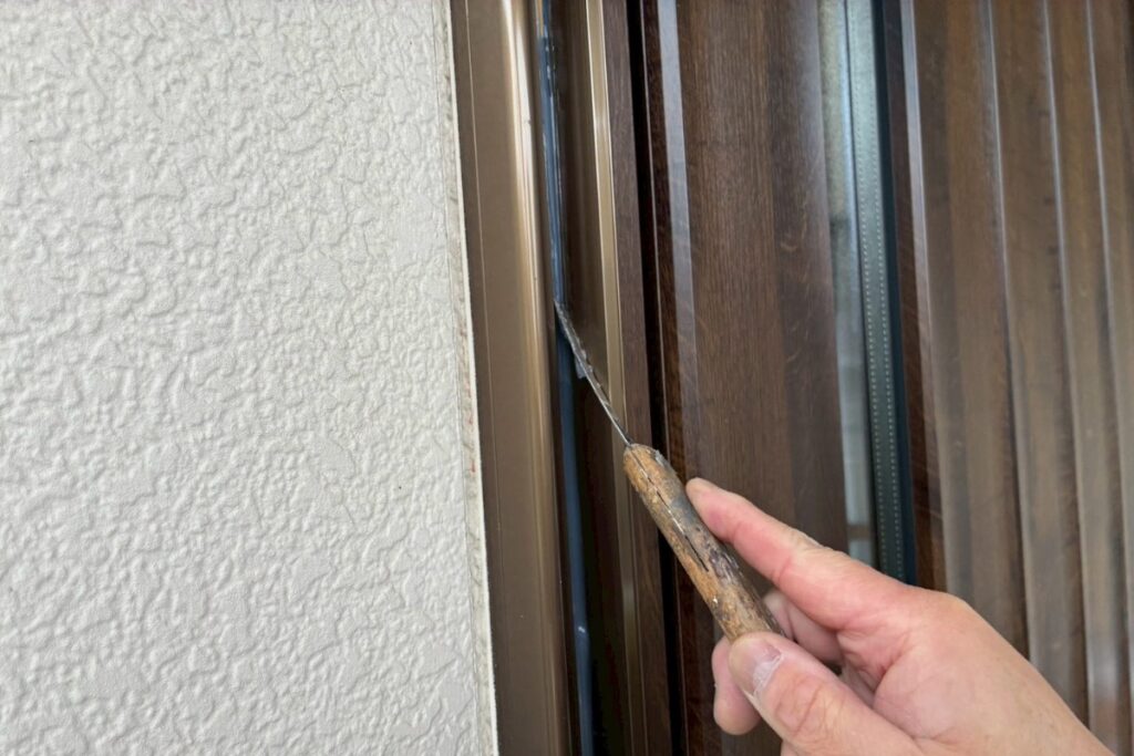 玄関ドア枠のコーキングヘラ均し作業（仙台市）