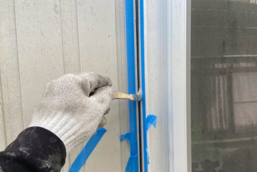 塩釜市で窓周りにプライマーを塗布している様子