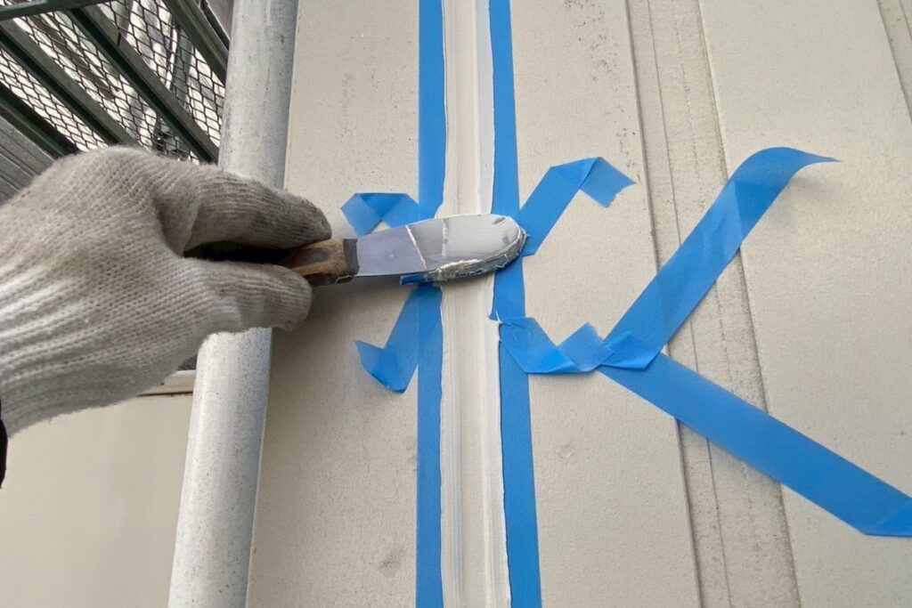 塩釜市でコーキングをヘラで均している様子