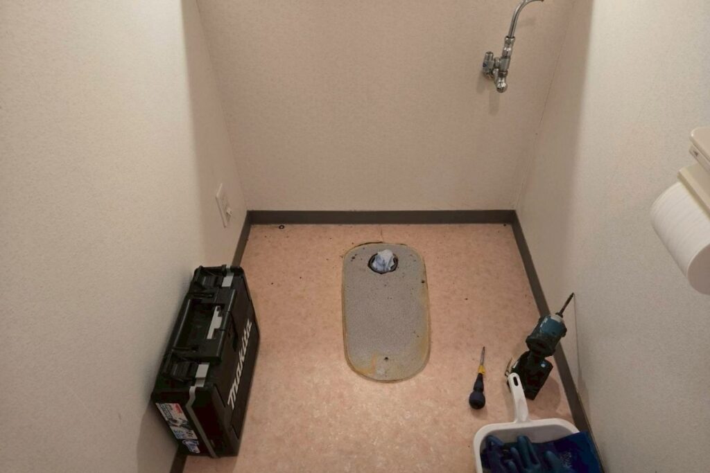 トイレ解体後の状態 床と排水口が見えている様子