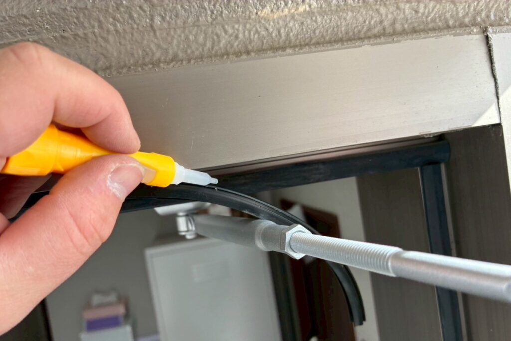 ドアパッキン交換作業で接着剤を塗布している様子