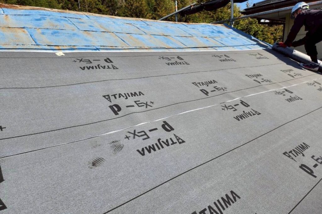 屋根にルーフィングを施工している様子