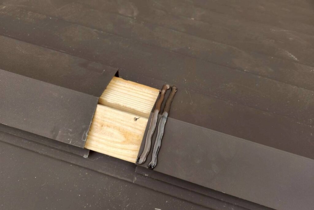 棟板金取り付けとコーキング施工の様子