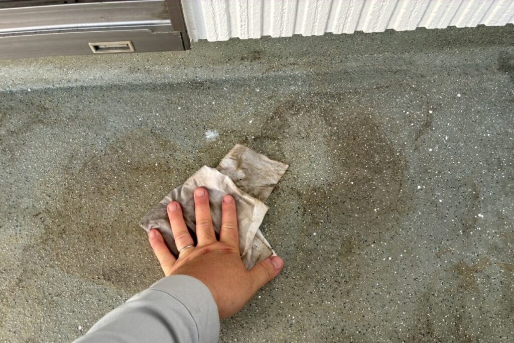 バルコニー床の汚れを拭き取り清掃している作業写真